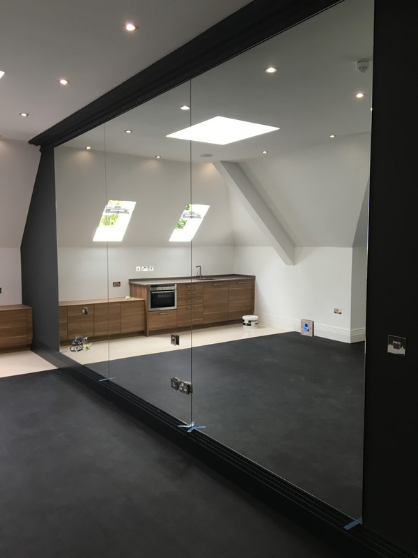 Frameless glass partition in loft conversion by Ascot glaziers