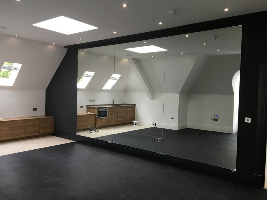Frameless glass wall dividing loft conversion in Ascot